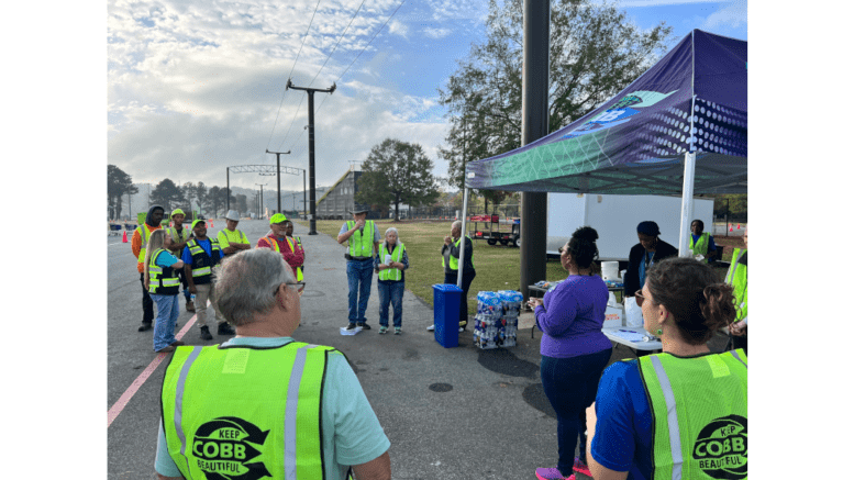 A group of people, some wearing event safety vests, at a recycling event