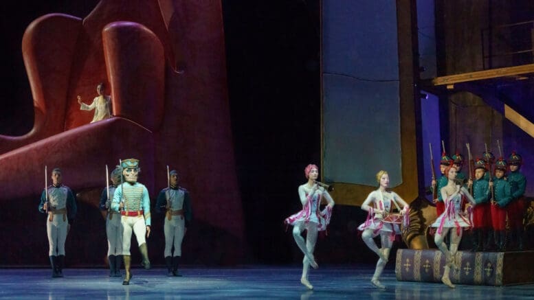 Atlanta Ballet performs The Nutcracker -- wooden soldiers are featured on the left, three female dancers on the right