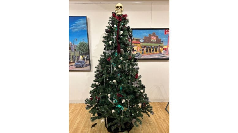 A decorated Christmas tree with a skull on top, described as a Gothic Christmas Tree