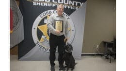 Retired Sgt. Ronnie Kite poses with retired drug dog K-9 Krush, a black lab