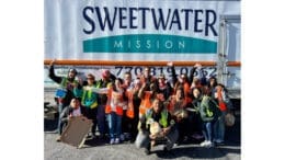 Group photo of volunteers at a Sweetwater Mission food distribution in Mableton standing in front of a large Sweetwater Mission semi trailer