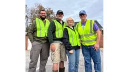 Four volunteers in yellow safety vests in group photo for Friends of Socktown litter cleanup