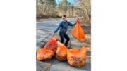 Mableton Councilwoman Patricia Auch displays orange bags of trash from a littler cleanup