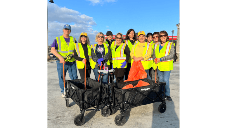 Atlanta Latino Lions group photo at litter cleanup of Windy Hill Road, all wearing yellow safety vests