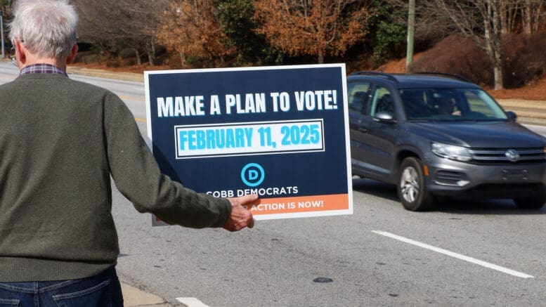 Man holding a Make a Plan to Vote sign