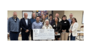 Group photo of representatives from local nonprofits in front of facsimile of check