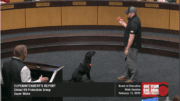 Trainer demonstrates a weapon-detecting dog at the Cobb County school board meeting