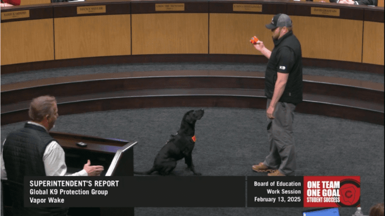 Trainer demonstrates a weapon-detecting dog at the Cobb County school board meeting