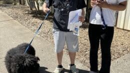 A couple with their newly adopted black poodle