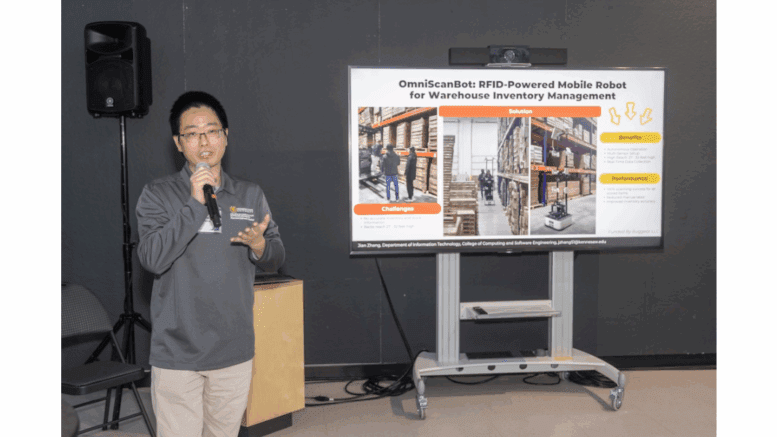 Jian Zhang standing with microphone in front of presentation board