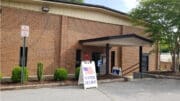 The front of the brick South Cobb Community Center building, with a "Vote Here" sign in front