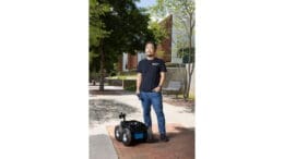 Taeyeong Choi with a wheeled robot below him at about shin height