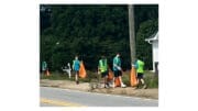 Scout Troop 22 picking up litter and placing it in orange plastic bags