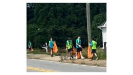 Scout Troop 22 picking up litter and placing it in orange plastic bags