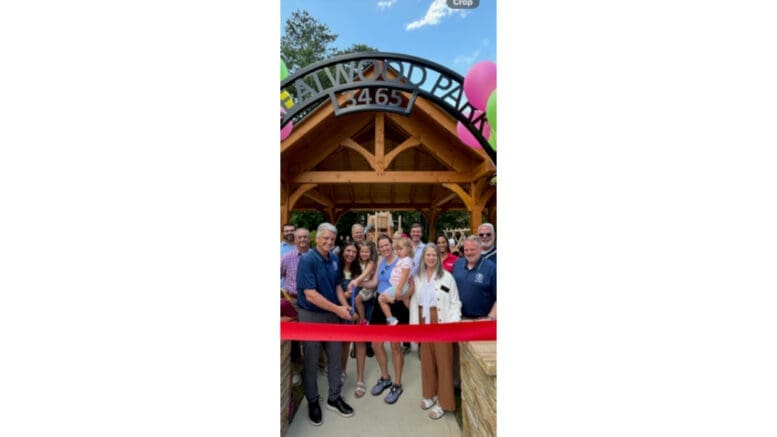 Group photo of residents in front of ribbon at Creatwood Park during opening ceremony