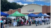 Students, parents and volunteers in front of booths at Mableton back to school bash