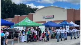 Students, parents and volunteers in front of booths at Mableton back to school bash