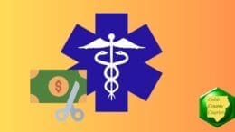 The star of life medical symbol alongside paper money being cut with scissors