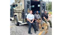 Austell officers and K-9 officer sitting on the back of an armored vehicle