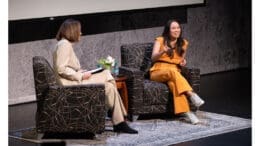 Schwaig and Pham seated on chairs on stage