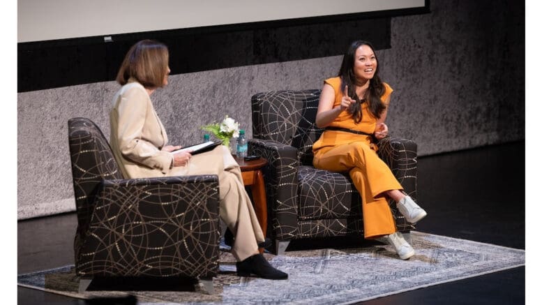 Schwaig and Pham seated on chairs on stage
