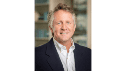 Headshot of Doug Jones with coat, dress shirt, no tie