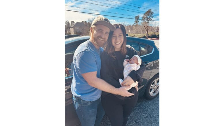 Photo of young couple holding newborn after a Cobb police officer saves the baby life
