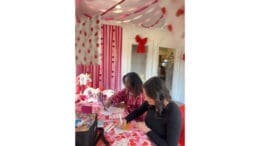 Two women signing Valentine cards