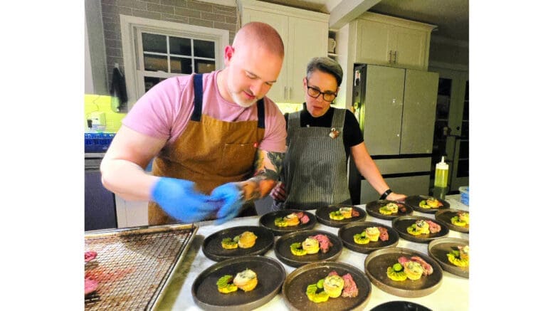 Kyle Shankman preparing food while a woman watches