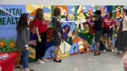Commissioner Monique Sheffield cuts the ribbon on the Paint Love mural