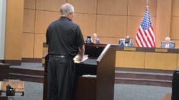 Public commenter at dais at Cobb school board meeting room