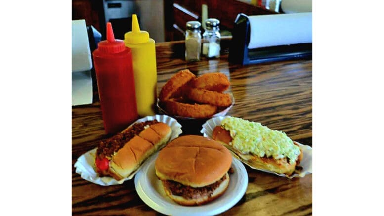 Photo of a hot dog, hamburger and onion rings with condiments