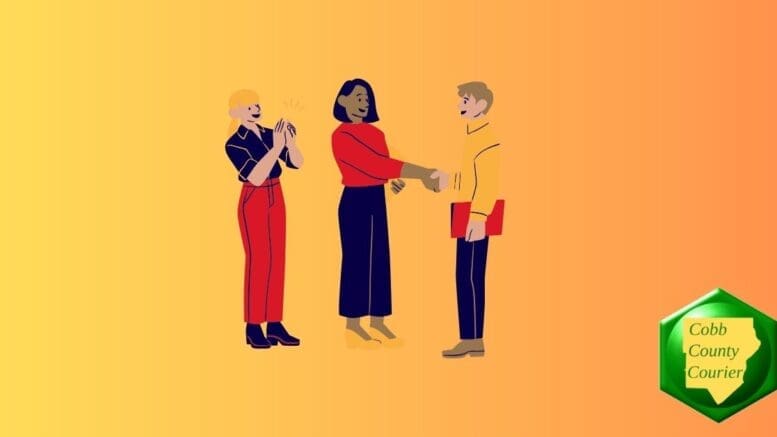 Three people in conversation, two of them shaking hands