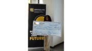 Woman holding up check from the Mookerji startup project