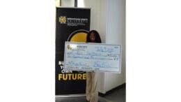 Woman holding up check from the Mookerji startup project